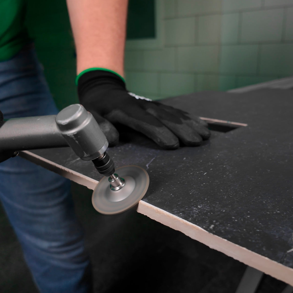 Person using a Distar Nectar grinding cup to work on a surface with a tiled wall in the background
